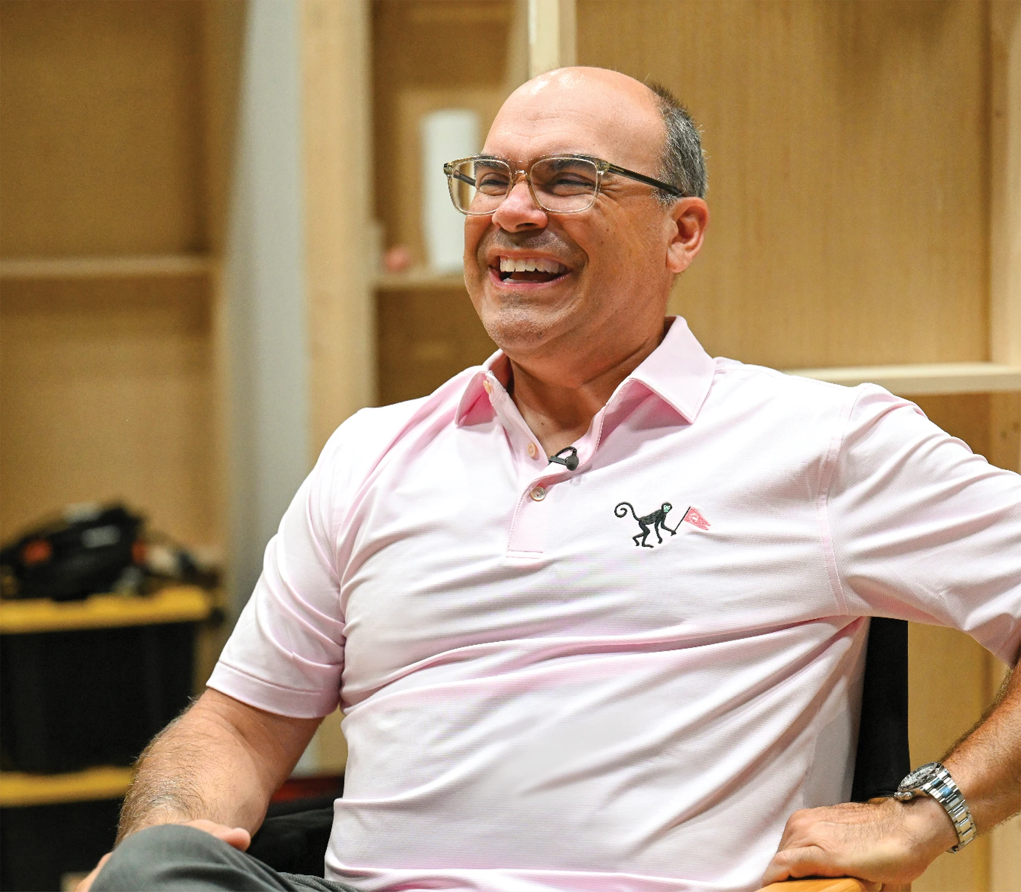 Felix Verdigets laughs while seated in a room with wood-paneled walls.