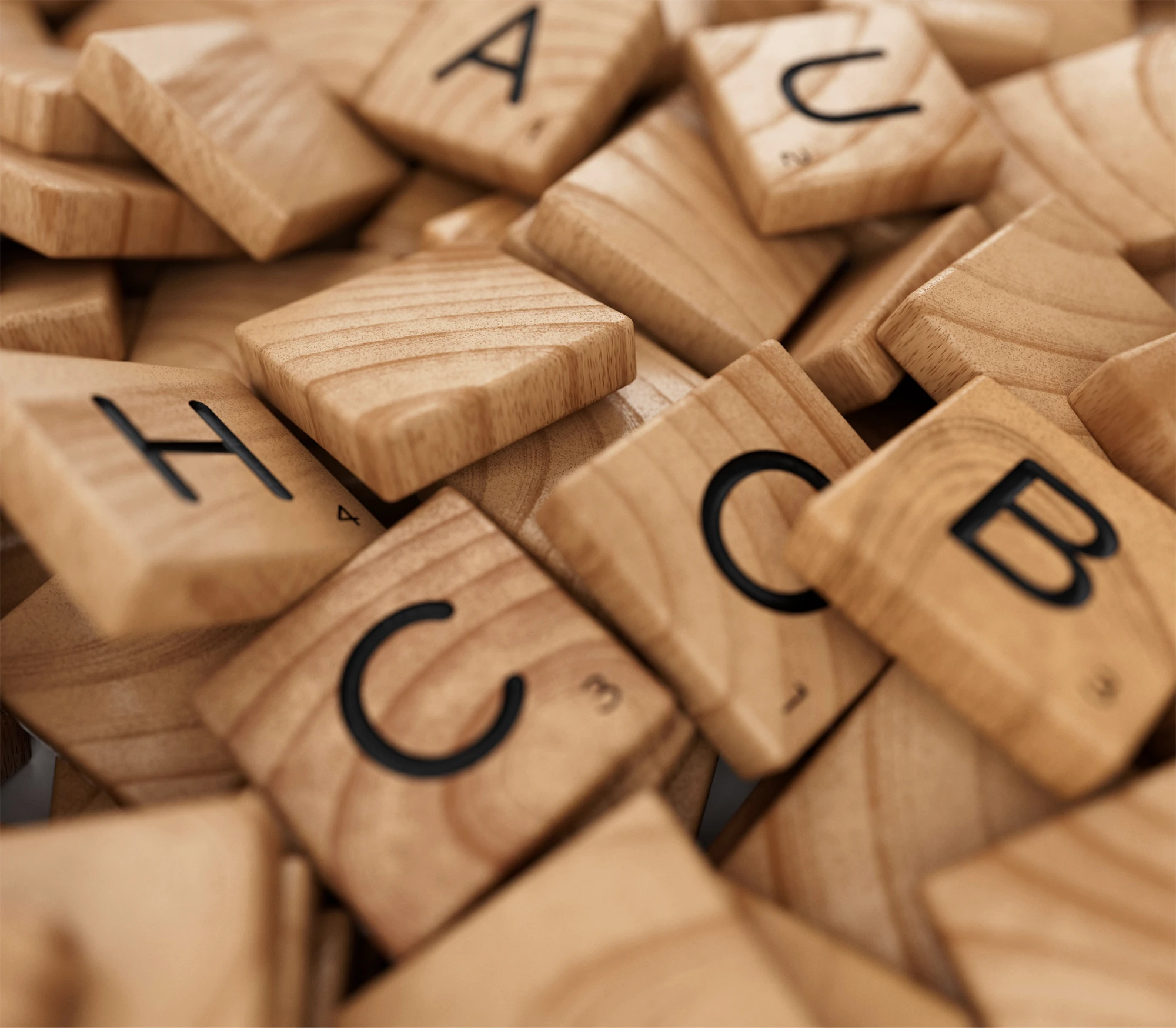 Close-up of scattered wooden letter tiles from a word game.
